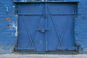 fermé vieux bleu porte dans une brique mur. photo