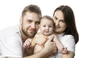 proche en haut portrait de Jeune Parents et bébé. père et mère baiser et étreinte une magnifique peu fils. le concept de aimer, content paternité et maternité. photo