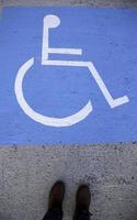 pieds sur un signe handicapé sur l'asphalte