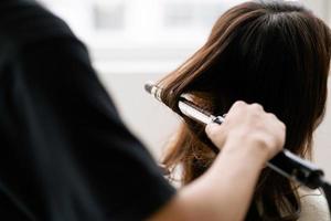 femme asiatique avec une expression heureuse faisant de la coiffure au salong photo