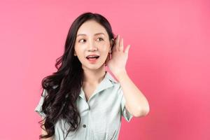 jeune femme asiatique mettant sa main à son oreille pour écouter photo