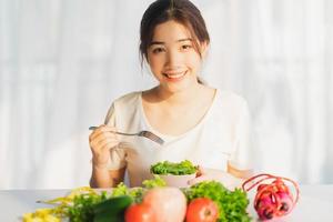 jeune femme mange des légumes verts pour perdre du poids photo