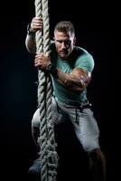 une crossfit athlète Faire corde grimpe isolé sur une audacieux pente Contexte photo