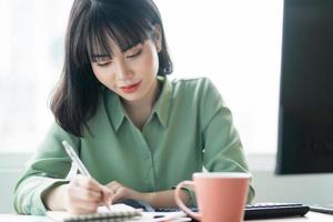 belle femme d'affaires asiatique travaillant attentivement au bureau photo