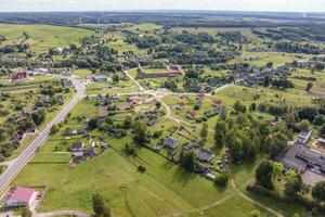 panoramique aérien vue de éco village avec en bois Maisons, gravier route, jardins et vergers photo