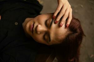 un asiatique homme en train de dormir sur une marron table avec longue cheveux pendaison vers le bas photo