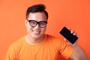 jeune homme asiatique tenant le téléphone avec une expression excitée photo