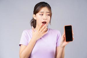 jeune femme asiatique montrant l'écran vide du smartphone photo