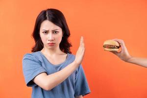 jeune femme asiatique abandonnant l'habitude de manger des hamburgers photo