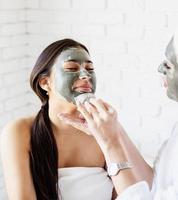 portrait d'une belle femme appliquant un masque facial faisant des procédures de spa photo