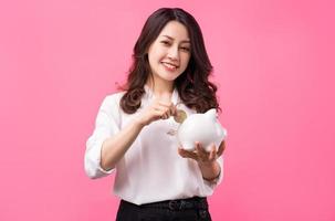 femme d'affaires asiatique tenant un cochon dans sa main, économisant de l'argent concept