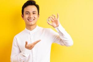 homme d'affaires asiatique tenant bitcoin dans sa main visage heureux wite