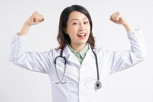 femme médecin asiatique levant ses mains dans une forme forte photo