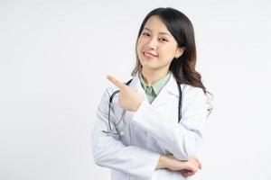 Portrait d'une femme médecin asiatique avec un visage joyeux pointant sur le côté photo