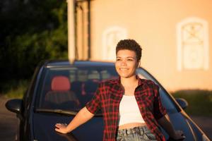 belle femme afro-américaine aux cheveux courts près de la voiture, mode de vie photo