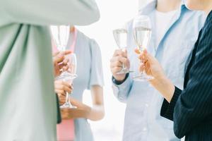 des hommes d'affaires asiatiques du groupe portent un toast ensemble et discutent lors d'une fête d'entreprise
