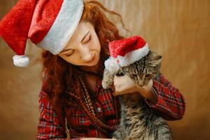 femme au chapeau de père noël avec chat au chapeau de noël. photo