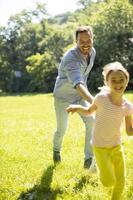 père pourchassant sa petite fille en jouant dans le parc photo