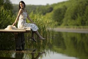 jeune femme relaxante sur une jetée en bois au bord du lac photo