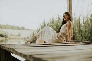 jeune femme relaxante sur une jetée en bois au bord du lac photo