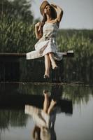 jeune femme relaxante sur une jetée en bois au bord du lac photo