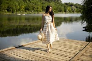 détente jeune femme debout sur une jetée en bois au bord du lac photo