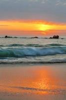 coucher de soleil orange et vagues turquoises photo