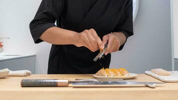 professionnel chef en train de préparer et cuisine brut Frais poisson ingrédient sur le table avec couteau pour délicieux Sushi et sashimi repas, la personne fabrication luxe omakase bien à manger Japonais nourriture restaurant dîner photo