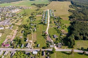 panoramique aérien vue de éco village avec en bois Maisons, gravier route, jardins et vergers photo