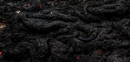 le lave surface refroidit et durcit dans Roche touffes de foncé noir lave photo