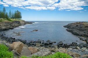 Naturel côtier Roche surface avec nuageux ciel et bleu océan l'eau dans Kiama, un de le principale touristique attractions dans Nouveau Sud Pays de Galles, Australie. photo