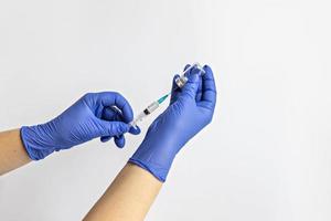 un travailleur médical en gants médicaux aspire une dose de vaccin contre le coronavirus dans une seringue. le concept de vaccination, immunisation, prévention des personnes de covid-19