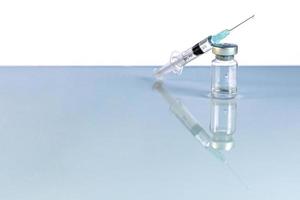 seringue et flacon avec vaccin contre le coronavirus, dose de flacon d'injection sur fond bleu. prévention, concept médical, vaccination covid-19. photo