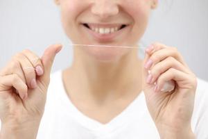 hygiène et soins dentaires. fil dentaire. visage de jeune femme en bonne santé avec un sourire de beauté. belle fille. santé de la personne. photo