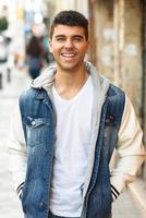 beau jeune homme aux yeux bleus marchant dans la rue photo