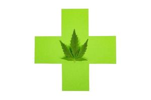 marijuana médicinale médicale, croix verte et feuille de cannabis isolé sur fond blanc photo