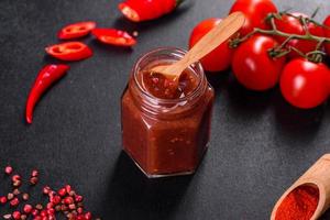 assaisonnement épicé de la cuisine géorgienne adjika dans un bol avec poivron rouge et ail photo