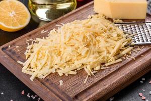 fromage frais râpé sur une grande râpe sur une planche à découper en bois