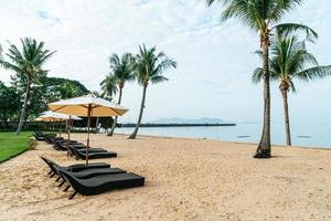 chaise de plage vide avec des palmiers sur la plage avec fond de mer photo