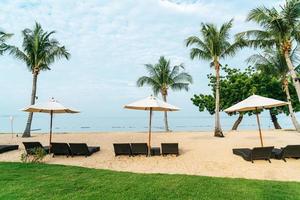 chaise de plage vide avec des palmiers sur la plage avec fond de mer