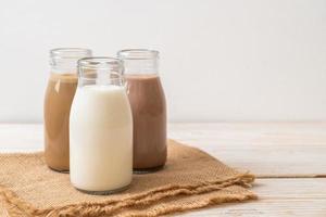 collection de boissons au lait au chocolat, café et lait frais en bouteille sur fond de bois photo