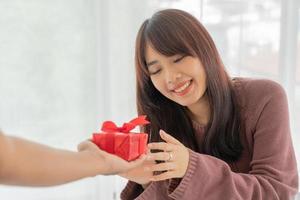 femme asiatique heureuse de recevoir un coffret cadeau ou un cadeau photo