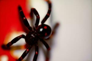 une proche en haut de une rouge araignée sur une blanc surface. ai généré photo