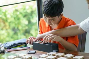 asiatique père et fils en jouant bois blocs Jeu insouciant enfant en jouant bois blocs Jeu bâtiment constructeur de blocs avec père à Accueil photo