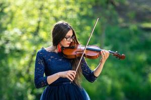 jeune femme jouant du violon au parc. faible profondeur de champ - image