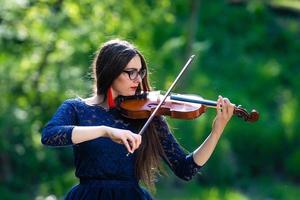 jeune femme jouant du violon au parc. faible profondeur de champ - image photo