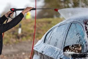 voiture sans contact lavage en libre-service. laver avec de l'eau et de la mousse. photo