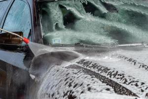 voiture sans contact lavage en libre-service. laver avec de l'eau et de la mousse. photo