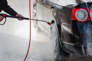 voiture sans contact lavage en libre-service. laver avec de l'eau et de la mousse. photo