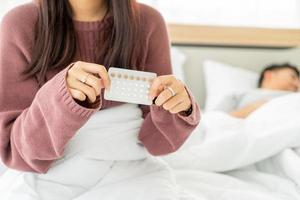 femme asiatique tenant la pilule contraceptive
